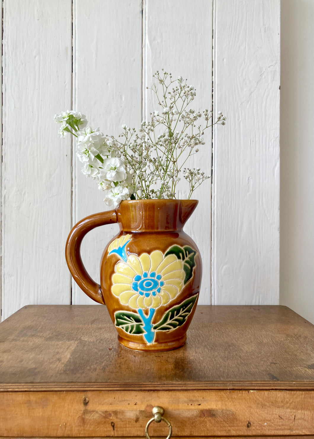 Amber jug with scraffito floral decoration