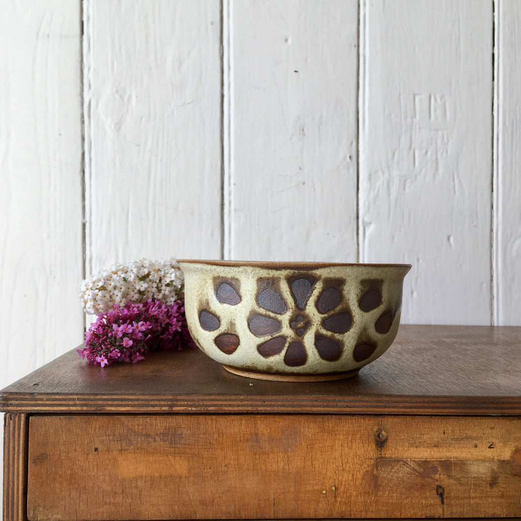 A hand-thrown stoneware studio pottery bowl with floral decoration