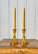 Load image into Gallery viewer, A pair of amber pressed glass candlesticks
