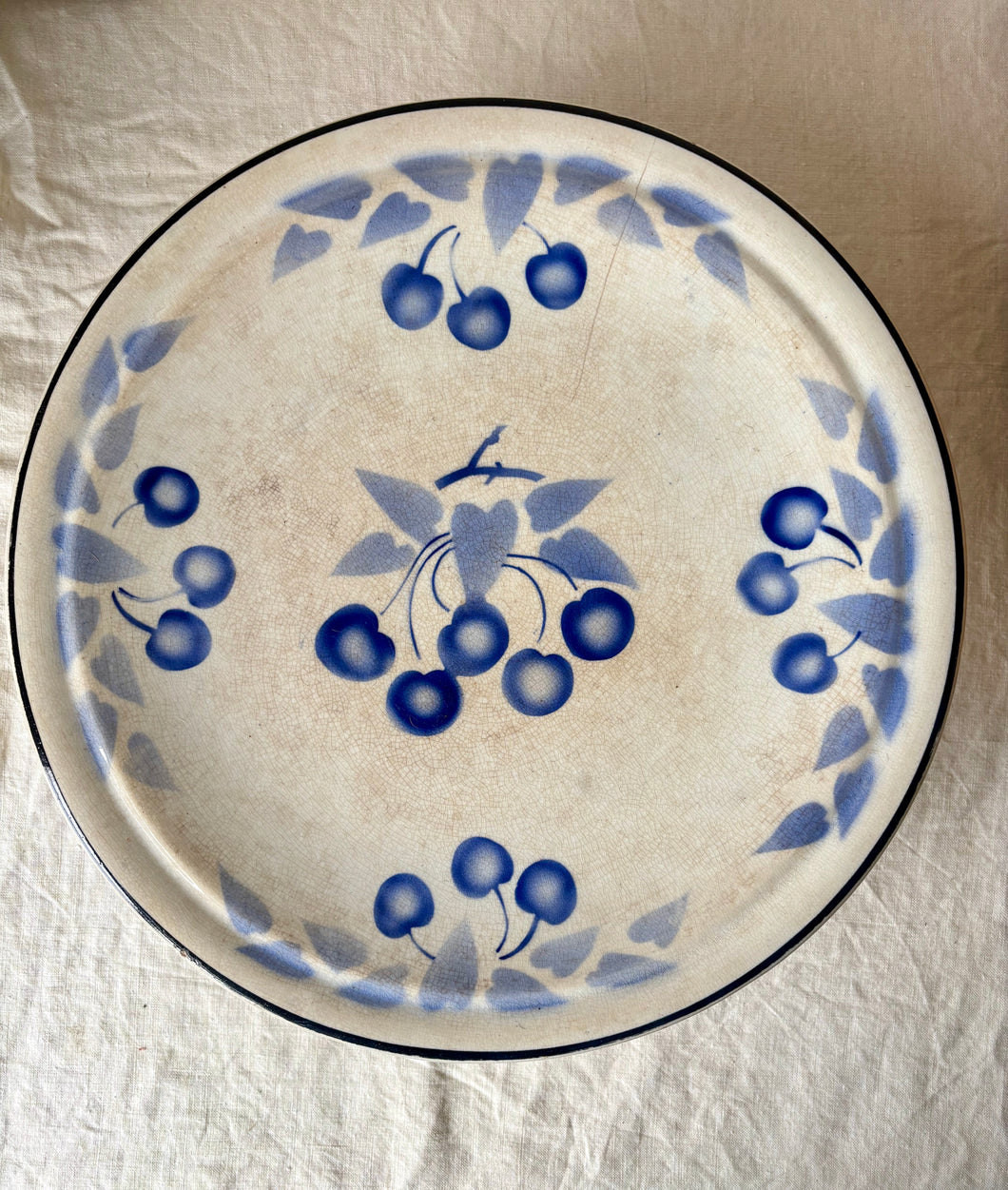 Large time-worn blue and white French cake stand with cherries