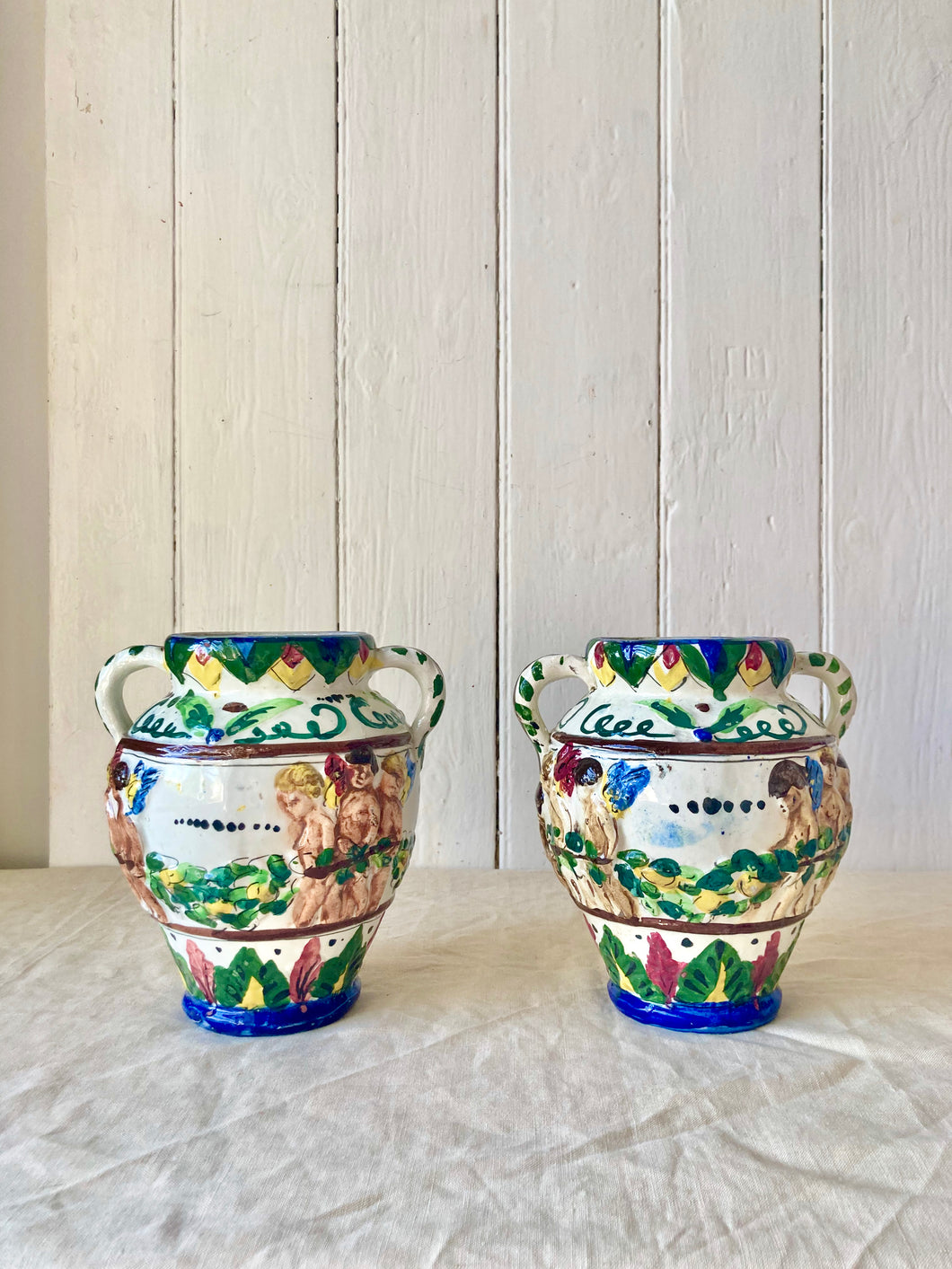 A pair of Italian putti vase with double handles
