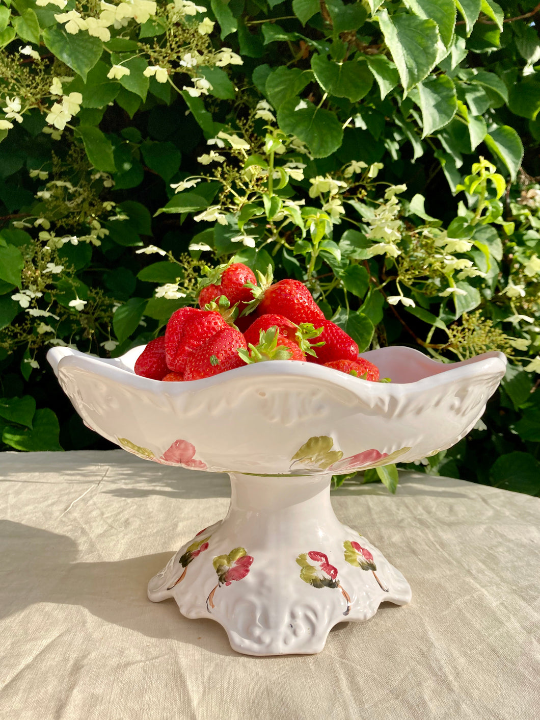 A large white and floral pedestal dish