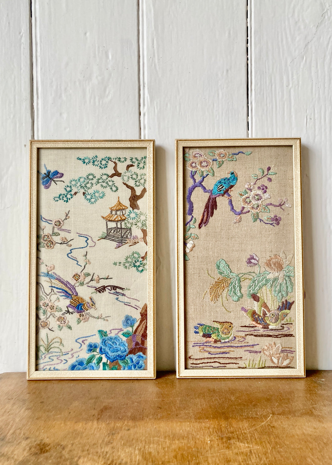 A pair of framed embroidered oriental-style panels