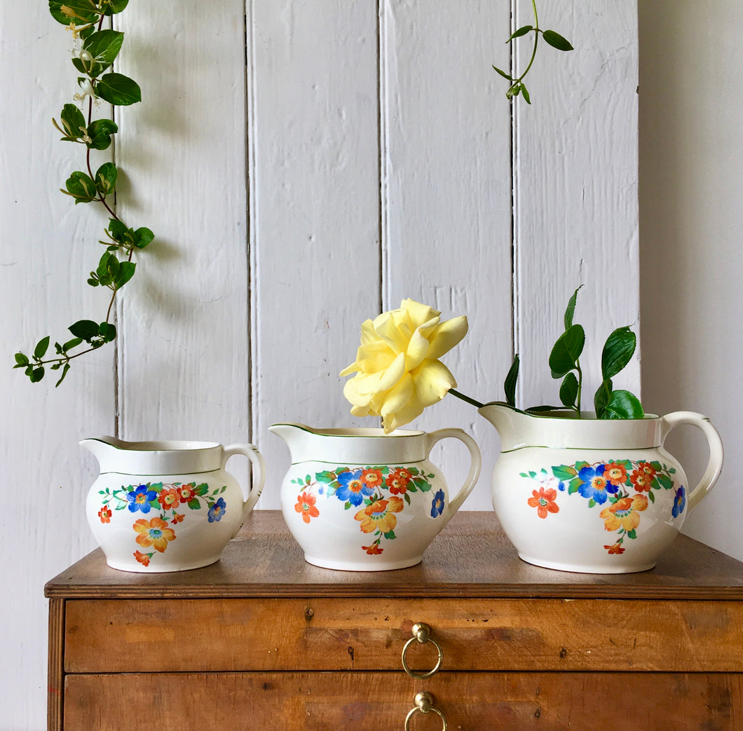 A trio of graduated floral jugs by C.W.S.
