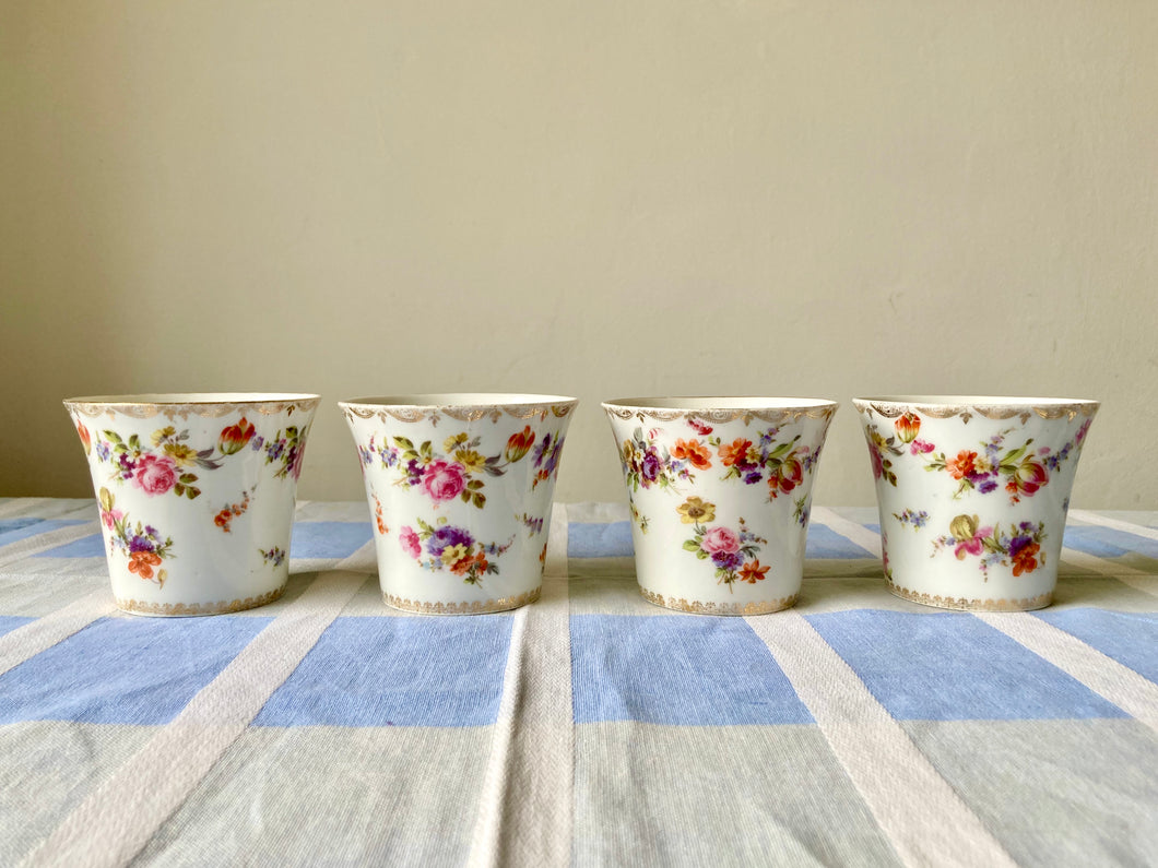 A set of four porcelain mini vases or planters
