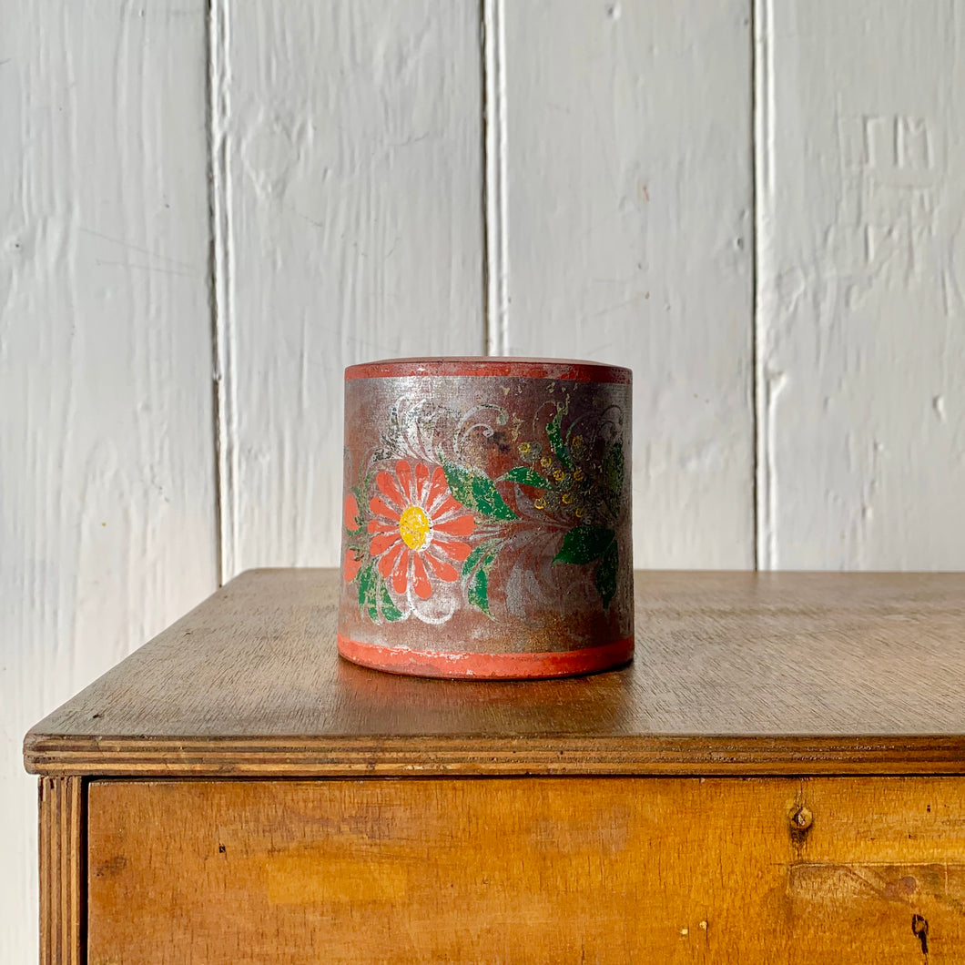 Aged decorative wooden pot with floral design