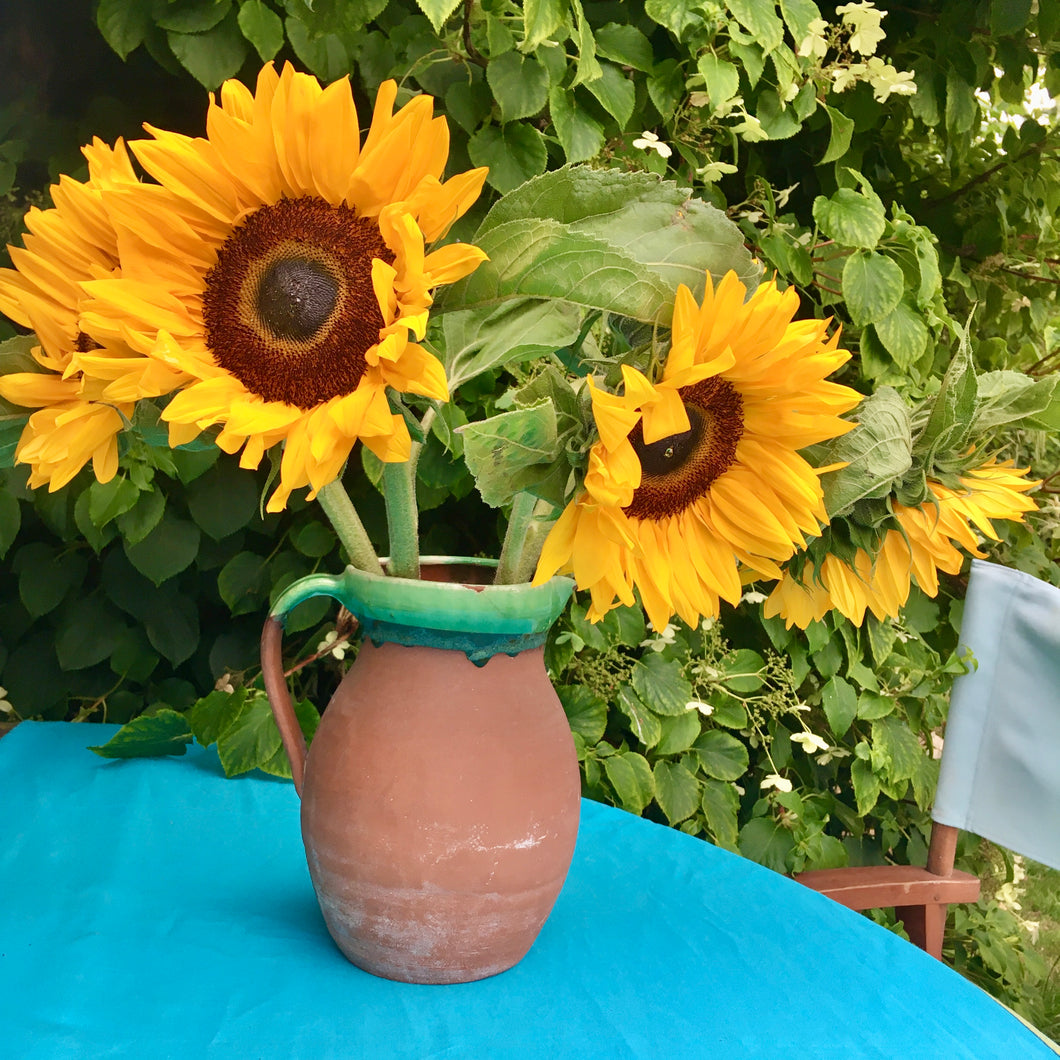 Large antique terracotta jug with green slip glazed rim